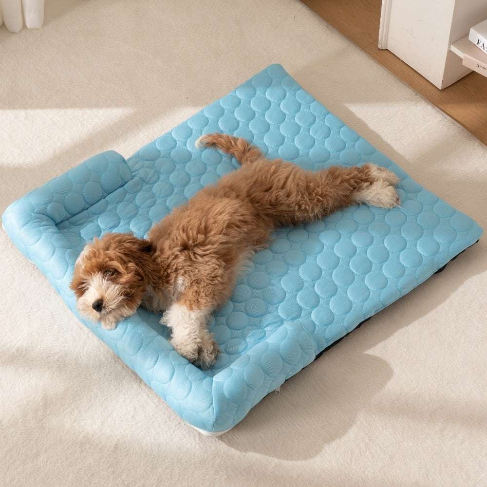 Bed Pet Cooling Mat in light blue quilted fabric with raised rounded cushioning, shown supporting a small brown-and-white dog