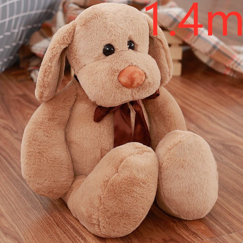 Cute Dull Dog Doll in light brown short plush, with floppy ears, an orange nose, dark eyes and a brown bow