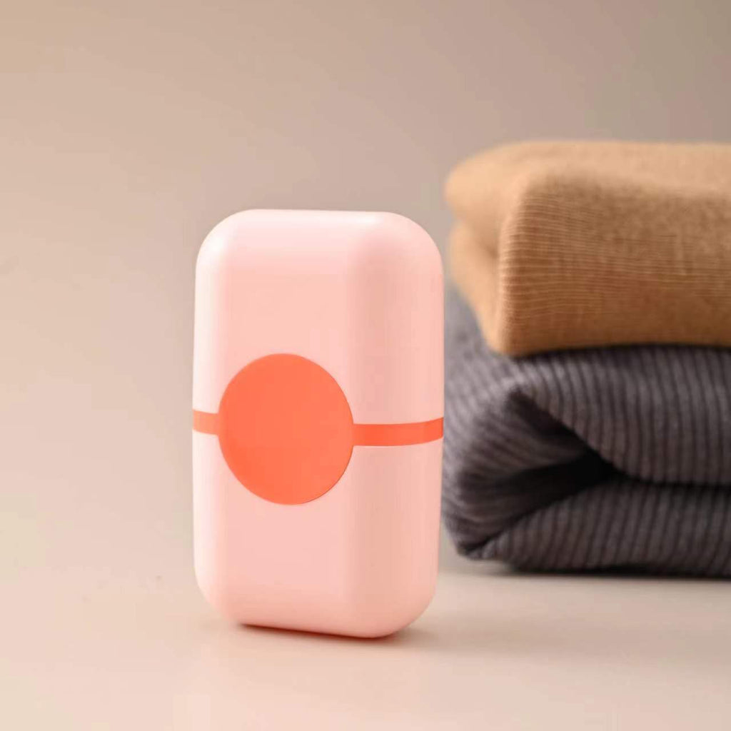 Pet Hair Double Headed lint roller in pale pink ABS plastic with a bright coral circular emblem and matching stripe