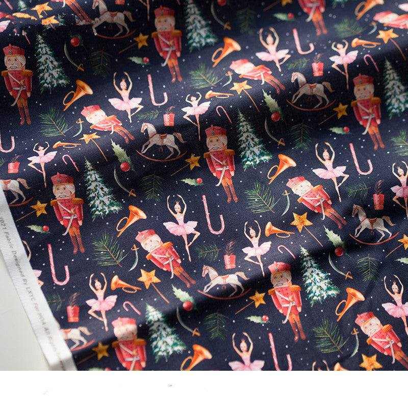 Printed Nutcracker Fabric in dark navy cotton, patterned with red nutcracker soldiers, ballerinas, trees, stars and candy canes