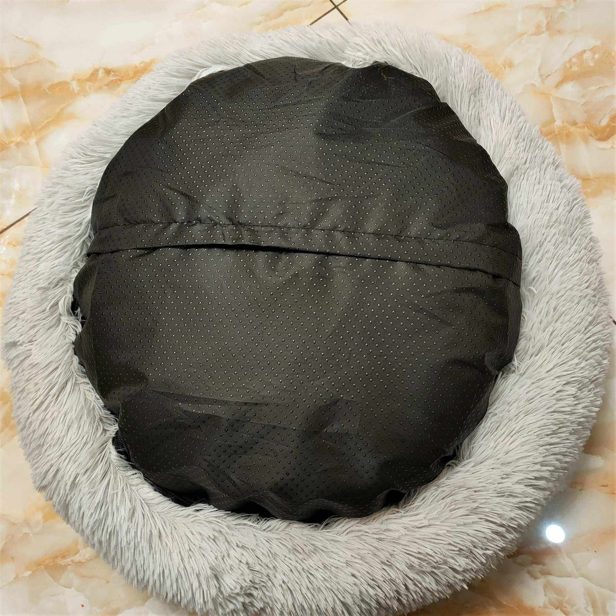 Removable And Washable Dog Bed with a black dotted fabric base and thick light gray plush fur rim