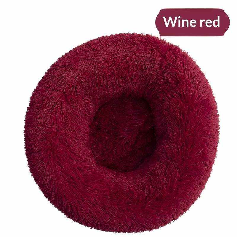 Removable And Washable Dog Bed in wine red plush, with a round nest shape, raised fluffy rim and recessed center